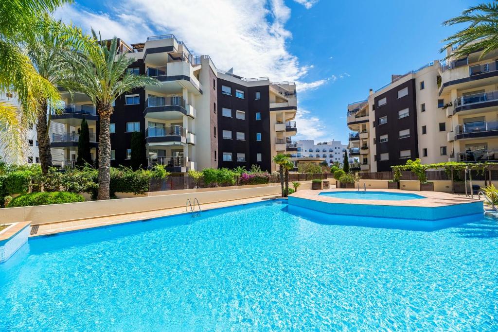 a large swimming pool in front of some buildings at Ático dúplex en Santa Eulalia junto a la playa in Santa Eularia des Riu