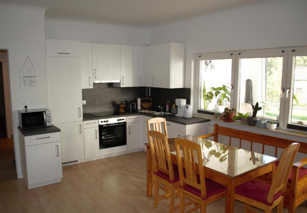 a kitchen with white cabinets and a table and chairs at Apartment Moni in Lutzmannsburg, 1 km von der Sonnentherme entfernt - Apartment mit 3 Schlafzimmern in Lutzmannsburg