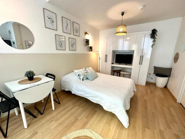 a bedroom with a bed and a table and a mirror at Studio, Sea and the Beach in Le Havre