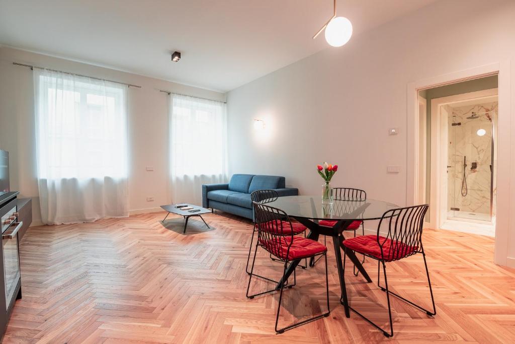 een woonkamer met een tafel en stoelen en een bank bij Roma Luxe Suite in Turijn