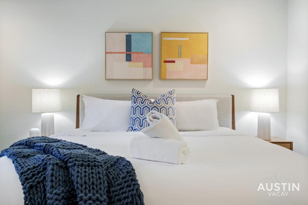 a white bed with a blue blanket on it at Close to Barton Springs and Zilker w King BR and Patio in Austin