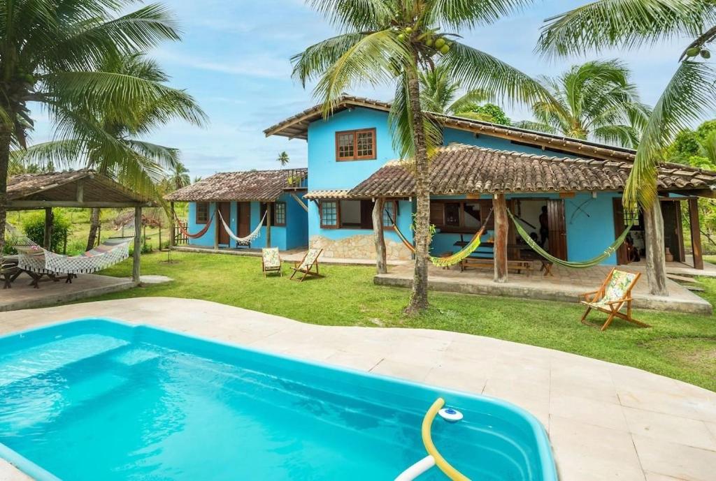 a villa with a pool and a house at Recanto de tranquilidade próximo a Morro e Boipeba. Casa espaçosa com piscina a 5 minutos a pé da Praia. in Garapuá