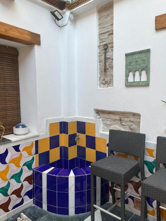 Habitación con suelo de baldosa colorido y 2 sillas. en Apartamento patio de los leones, en Granada