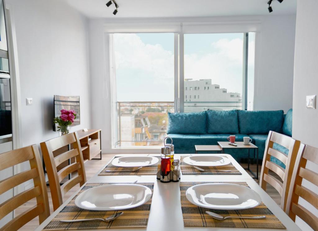 a dining room with a table and a blue couch at Urban Serenity City Skyline View Apartment 1 in Tirana