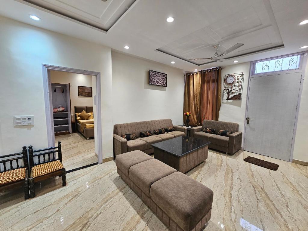 Ankhi's Villa with Parking في أمريتسار: غرفة معيشة مع أريكة وطاولة