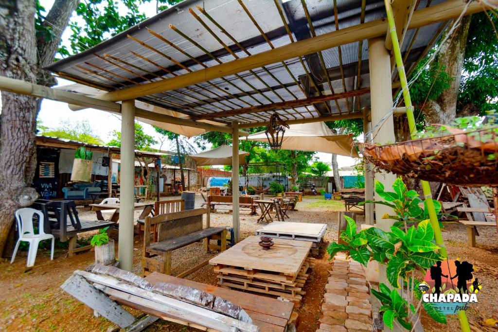 a patio with a table and chairs and an umbrella at Hostel Chapada Dos Guimarães in Chapada dos Guimarães