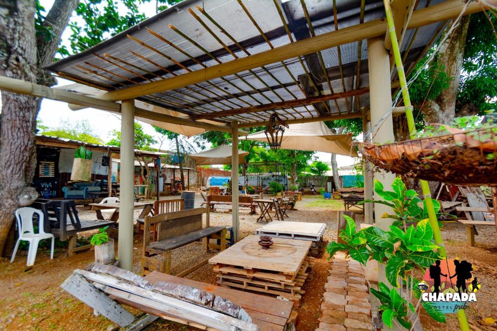 un patio con mesa, sillas y sombrilla en Hostel Chapada Dos Guimarães, en Chapada dos Guimarães