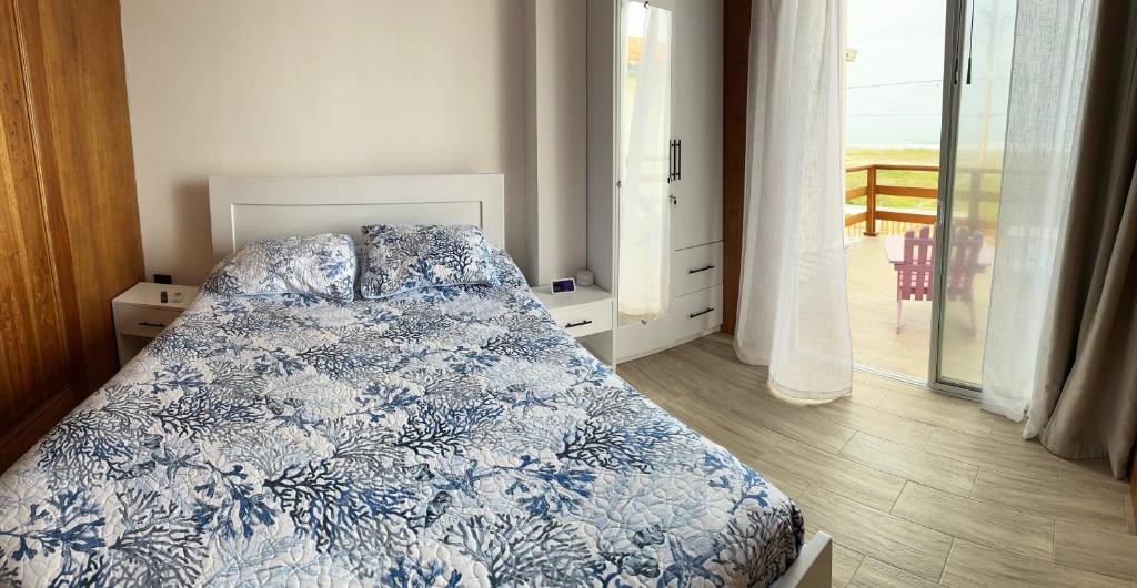 1 dormitorio con 1 cama con manta azul y blanca en Casa Caballito de mar-Seahorse House en Bahía de Caráquez