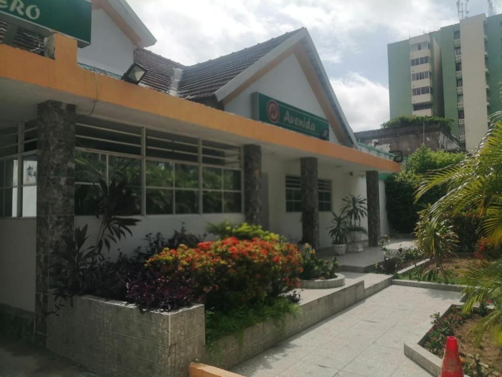 un edificio con flores delante en hotel avenida53, en Barranquilla