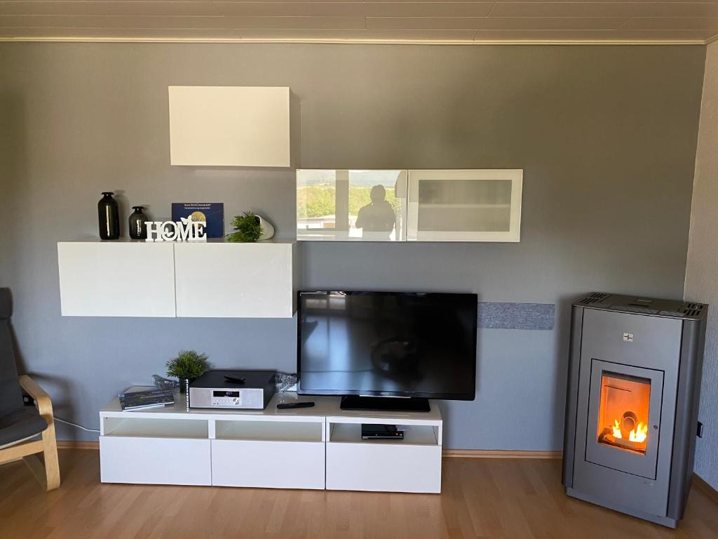 a living room with a tv and a fireplace at Ferienwohnung Augenblick in Medebach
