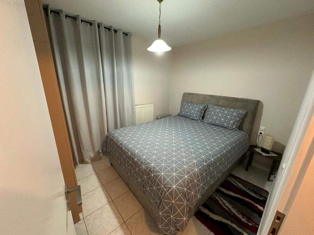1 dormitorio con cama con colcha gris en Palaiomonastiro mountain resort 1, 