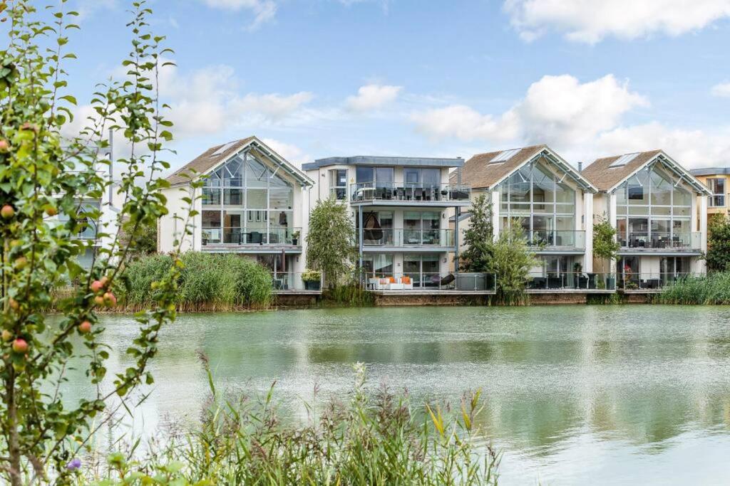 an image of an apartment complex next to a lake at Skylark Lodge HM24 HOT TUB Lakeside Spa in Somerford Keynes
