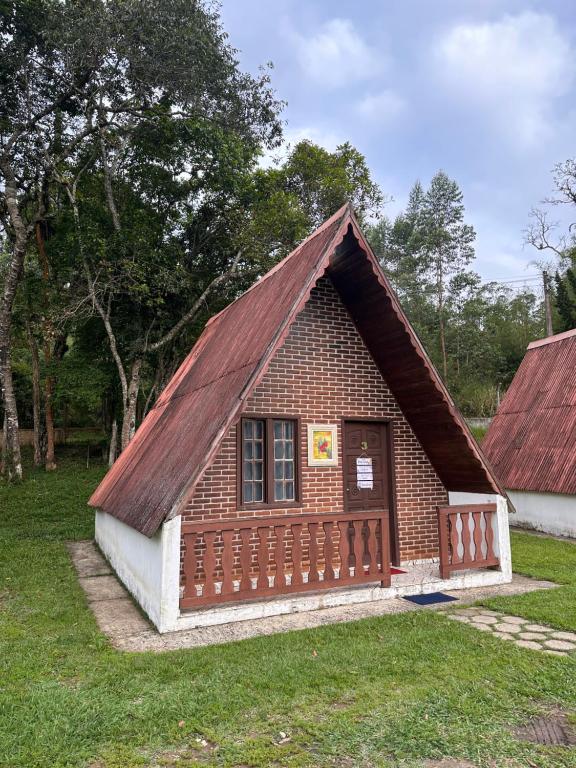 ein kleines Backsteingebäude mit rotem Dach in der Unterkunft Chalé 3 Descanso nas Nascentes in Salesópolis