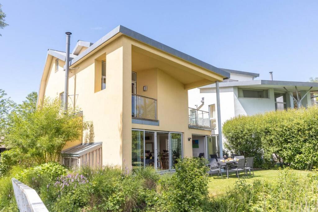 a house with a garden in front of it at Tawny House CW6 Lakeside Spa Property in Somerford Keynes