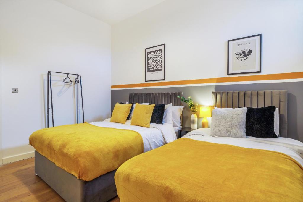 a bedroom with two beds with yellow sheets at Spacious City Centre Apartment - Sleeps 8 in Liverpool
