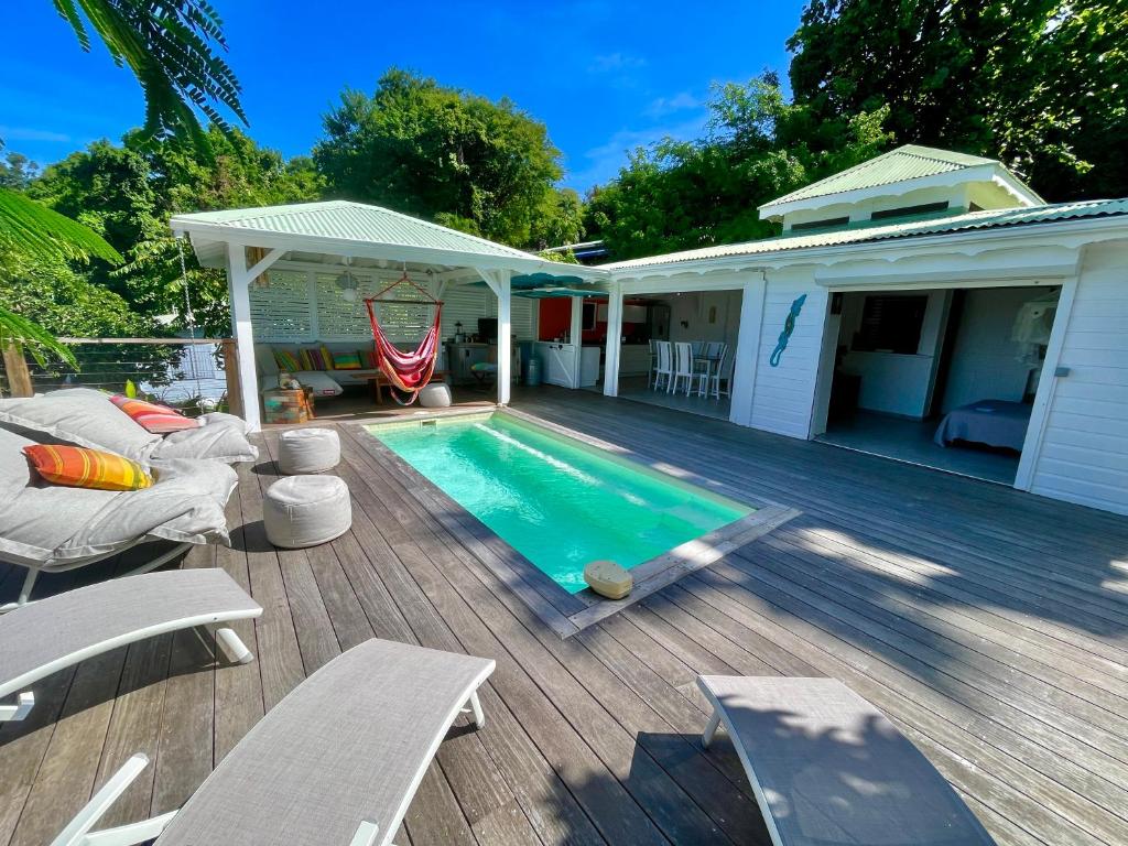 a backyard with a swimming pool and a house at Villa Orsalina Pointe Batterie in Deshaies