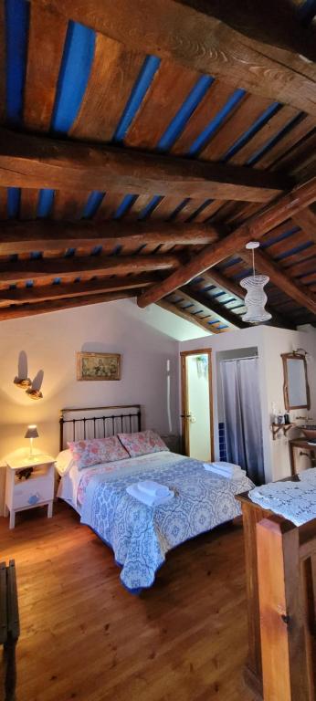 a bedroom with a large bed and a wooden floor at Casas Quo Vadis -Azul in Lugo
