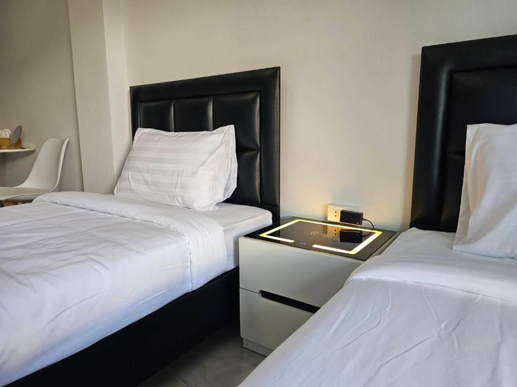 Cette chambre comprend deux lits et une table avec un plateau. dans l'établissement Ban Chahomm Guesthouse, à Betong