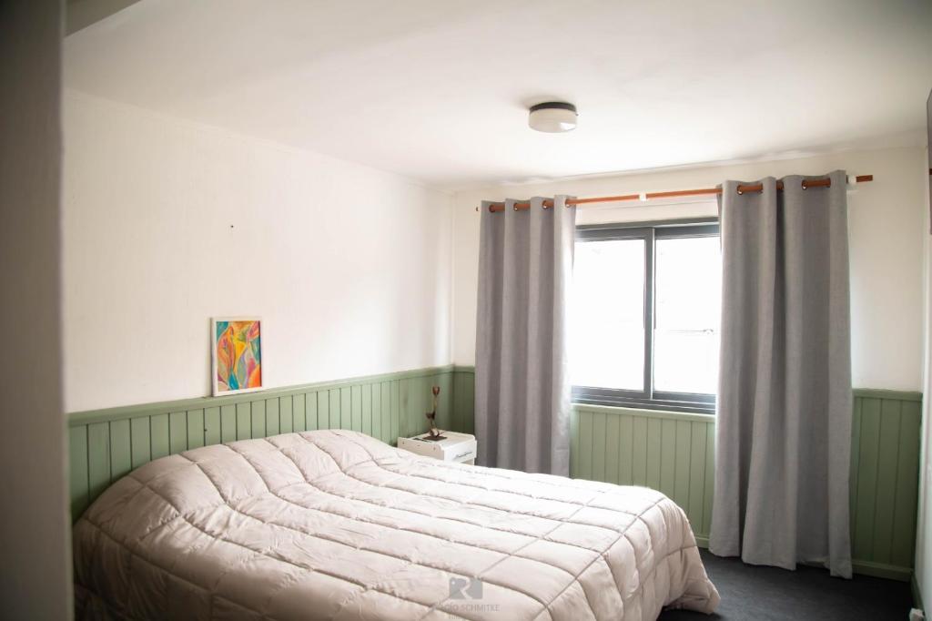 um quarto com uma cama e uma janela em Hostería Las Rosas em Esquel