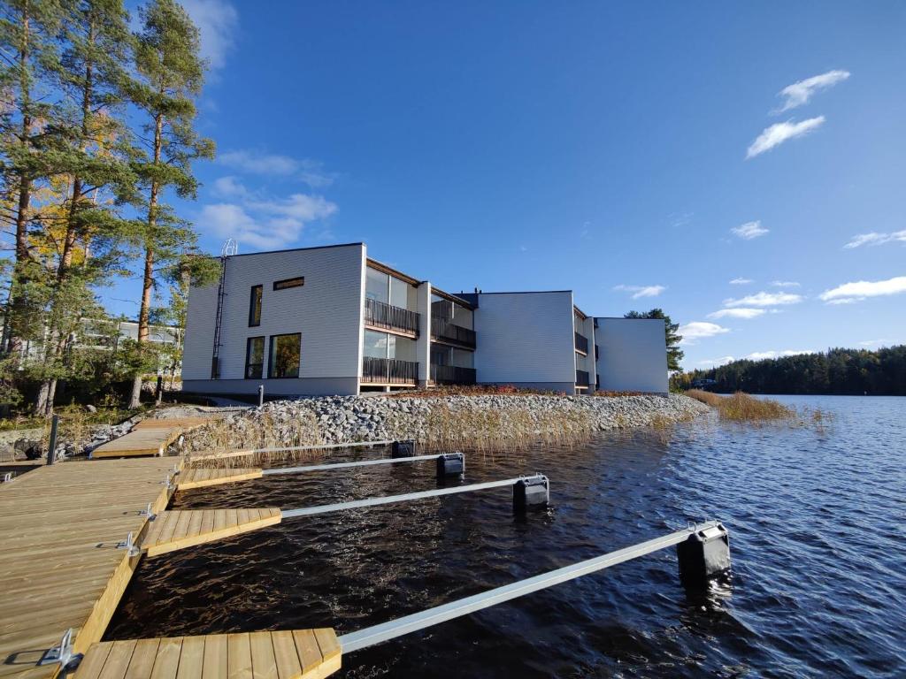 a house on the water with a dock at Pramea Apartments Kultaniemi in Kuopio