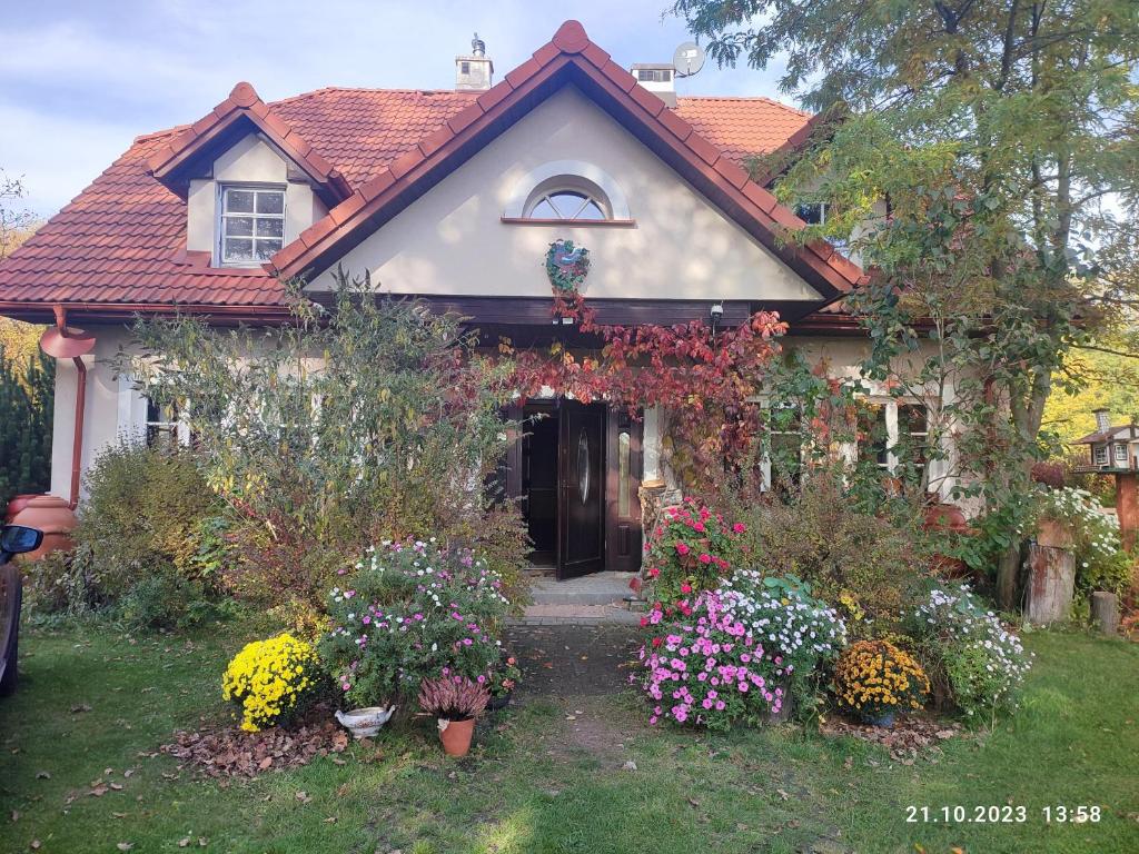 a house with a bunch of flowers in the yard at Apartament Urocze miejsce in Kazimierz Dolny