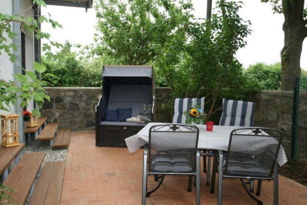 a patio with a table and chairs and a grill at Landhaus Immenbarg, Warnow in Warnemünde