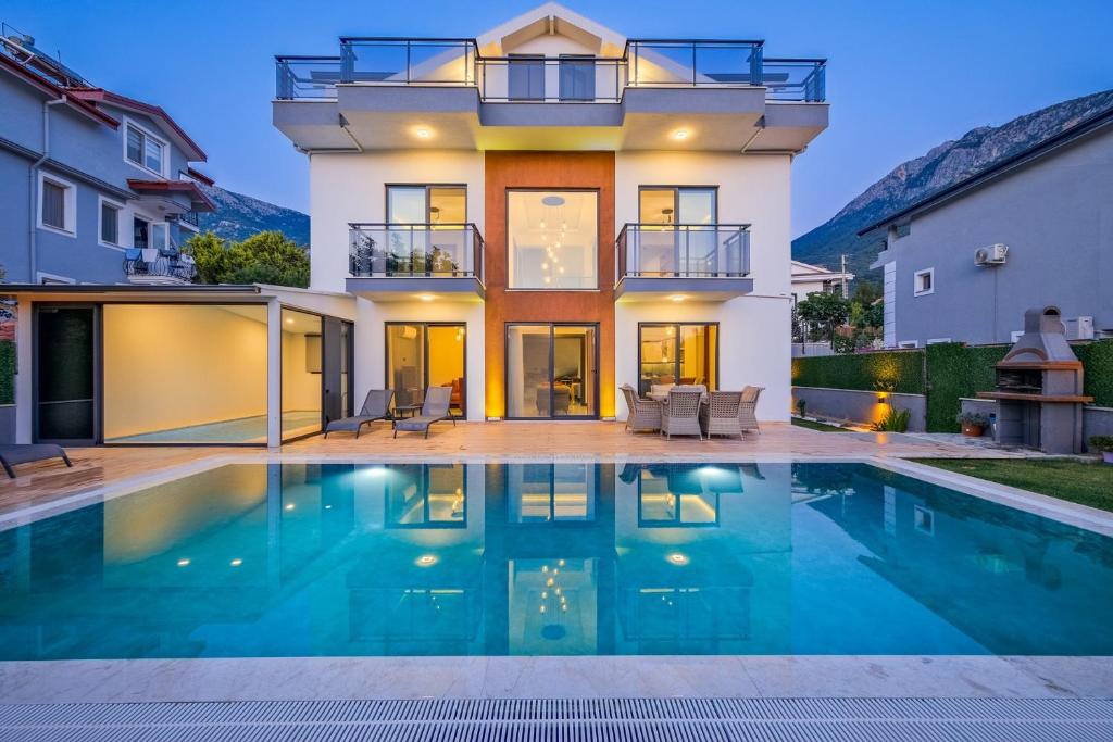 a house with a swimming pool in front of a house at Villa Lotus/ Ölüdeniz Isıtmalı kapalı havuzlu in Fethiye