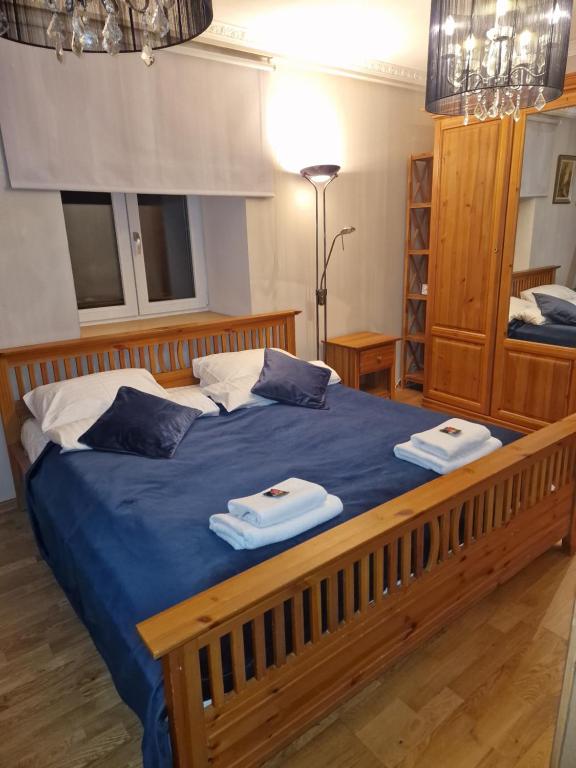 um quarto com uma grande cama de madeira com toalhas em Valley of Peace with free parking&playground em Ikšķile