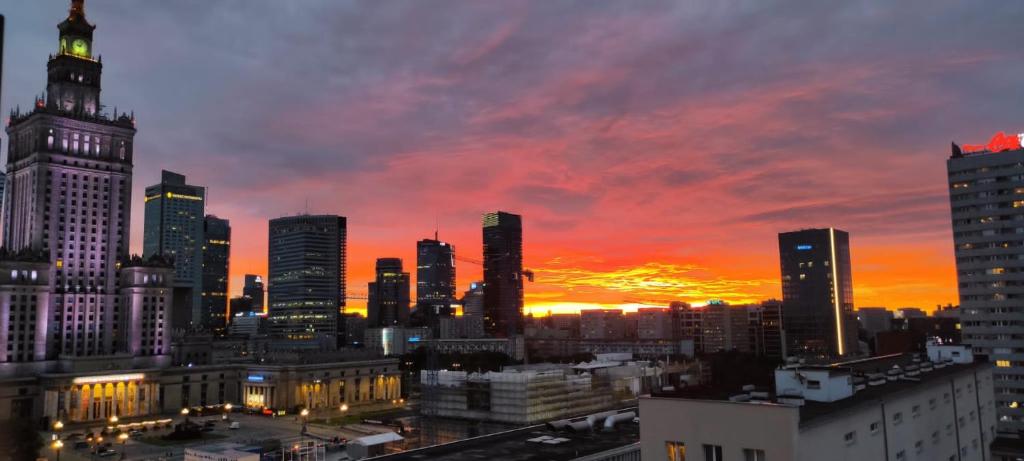 a view of a city skyline at sunset at ComeWa Apartments in Warsaw