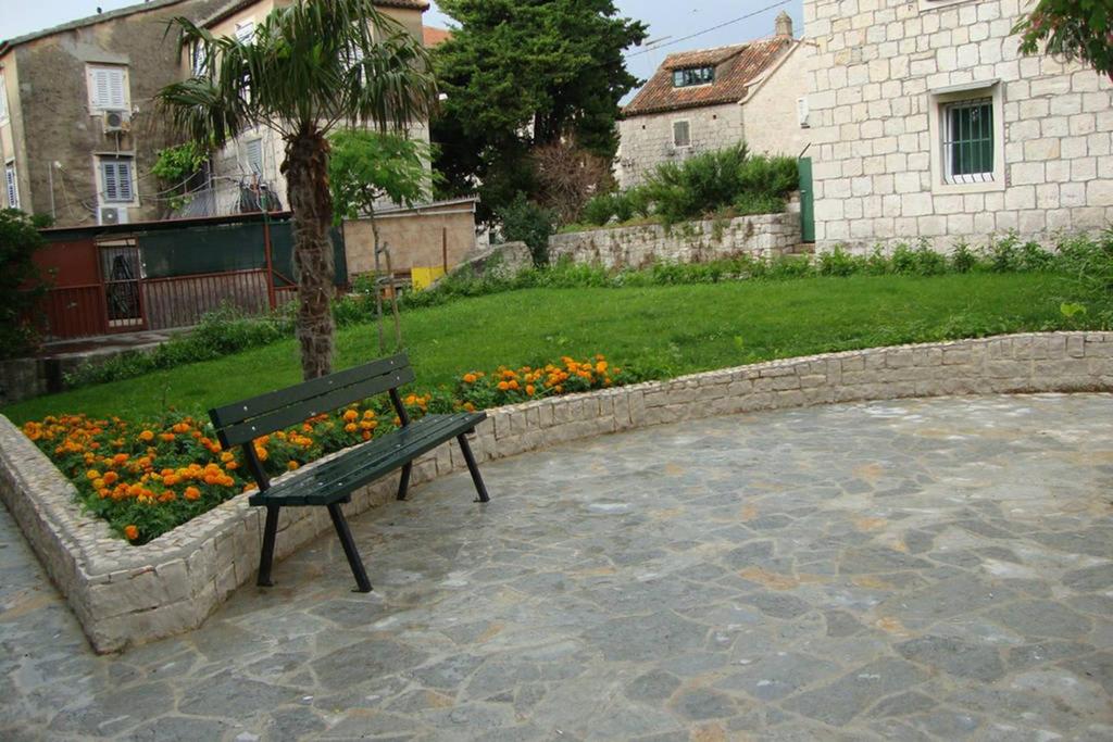 a park bench sitting next to a tree and flowers at Radunica Apartment in Split