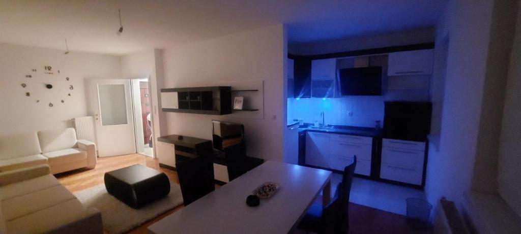 een woonkamer met een tafel en een keuken bij Apartman Centar 1 in Bijeljina