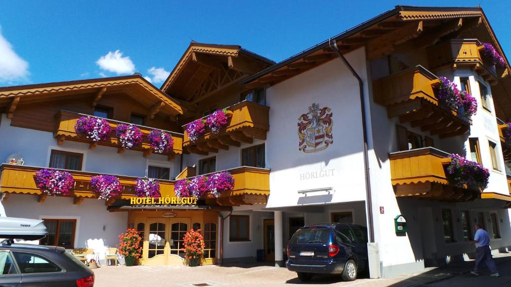 a building with flower boxes on the side of it at Hotel Hörlgut in Maria Alm am Steinernen Meer