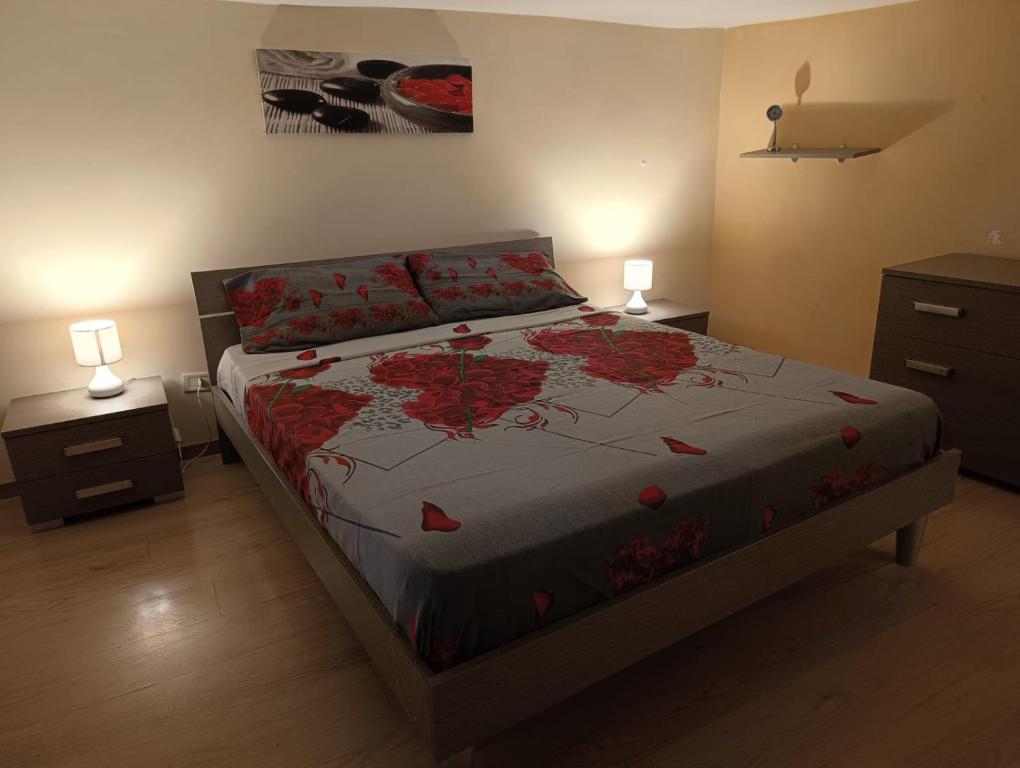 een slaapkamer met een bed met rode bloemen erop bij Onboarding! in Napels