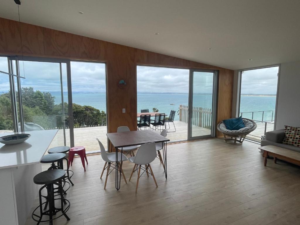 a kitchen and dining room with a view of the ocean at Whatuwhiwhi View in Karikari Peninsula