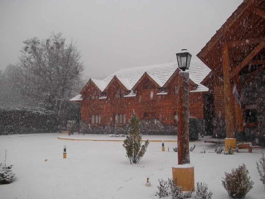 un edificio con un poste de luz en la nieve en Hosteria Maiten Escondido en Villa La Angostura