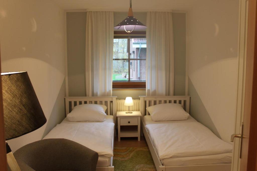 twee bedden in een kleine kamer met een raam bij Jacobihof Haus 3 Wohnung 01 in Dahme