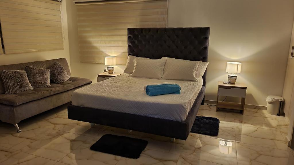 1 dormitorio con 1 cama grande y 1 sofá en PISCINA SARITA CLUB BOUTIQUE en Girardot