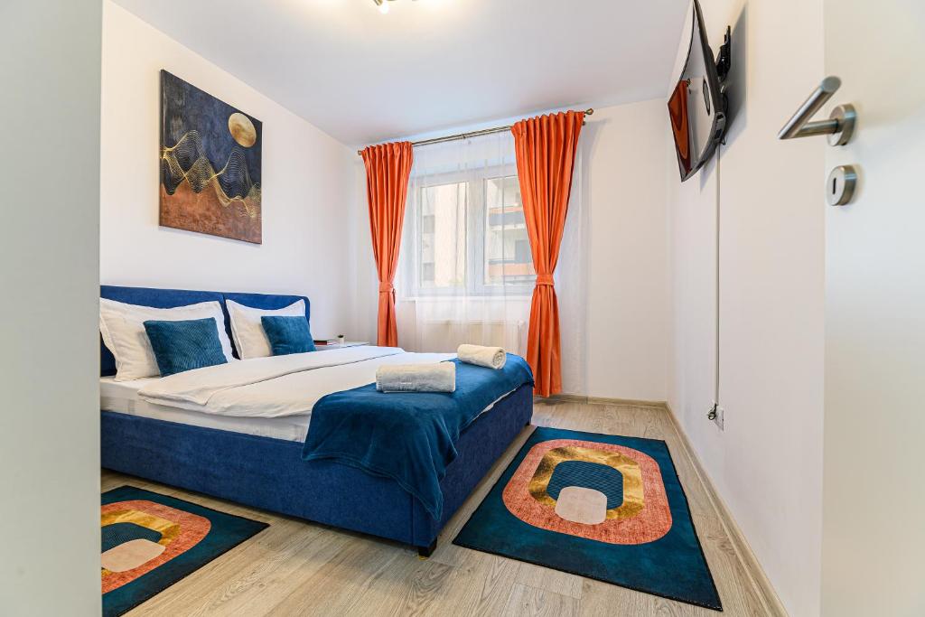 a bedroom with a bed and a window with orange curtains at Grandis Residence Apartment in Braşov