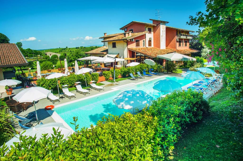 an overhead view of a swimming pool with chairs and umbrellas at Hotel Il Castello in Pozzolengo