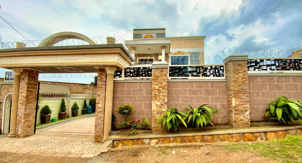 een huis met een poort en planten ervoor bij Serene villaz in Kampala