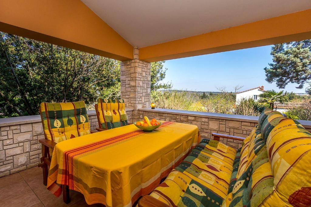 a yellow table and chairs on a balcony at Villa Nera in Banjole