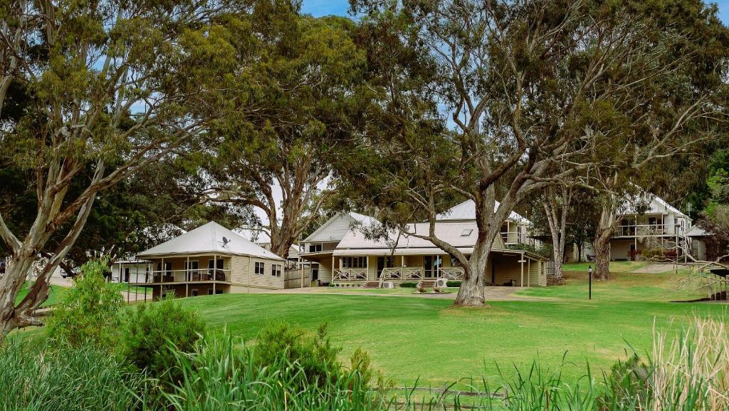 a large house with trees in front of it at McMillans of Metung Coastal Resort in Metung