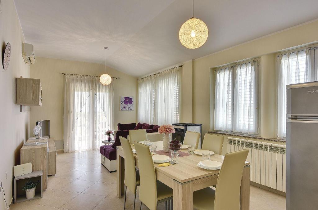 jadalnia i salon ze stołem i krzesłami w obiekcie Modernes Appartement mit Balkon, BBQ, WLAN, Klima w mieście Vodnjan