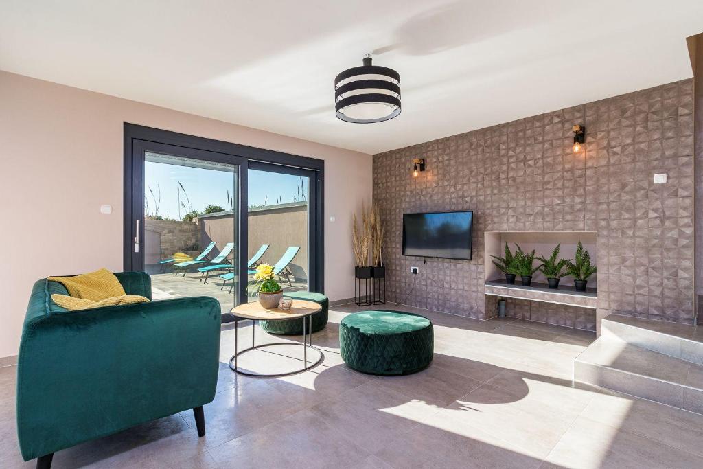 Telewizja i/lub zestaw kina domowego w obiekcie Luxuriöse Villa mit privatem Pool und Sonnenterrasse
