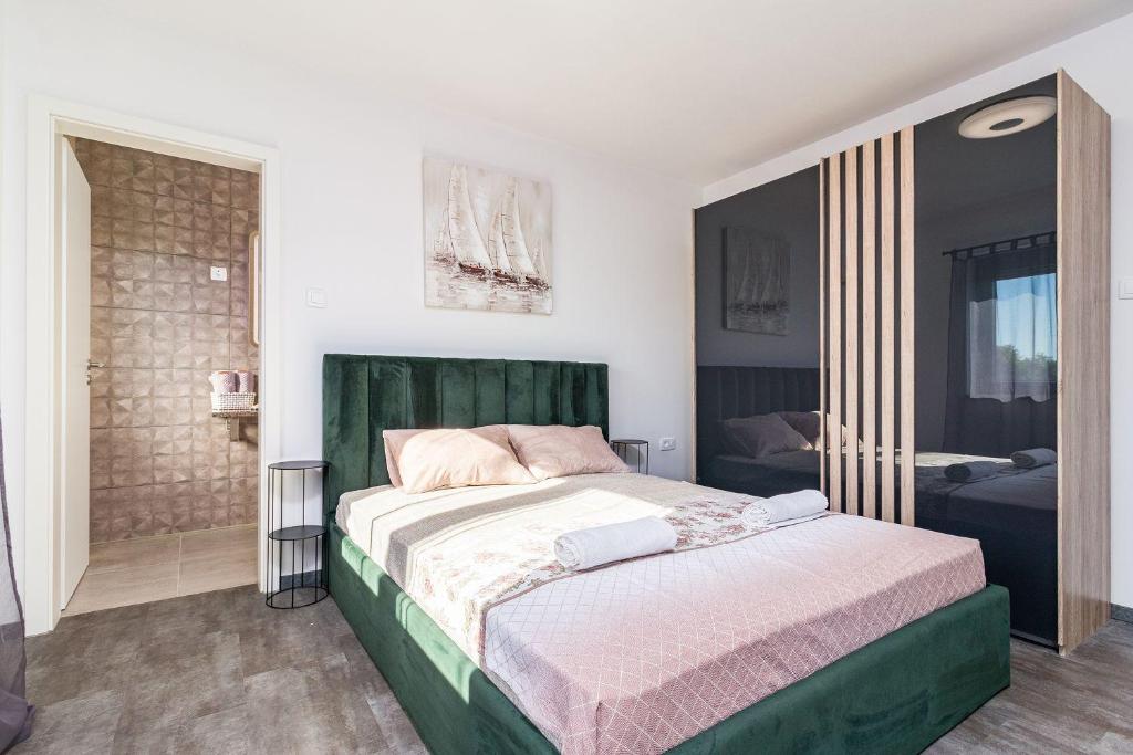 sypialnia z łóżkiem z zielonym zagłówkiem w obiekcie Luxuriöse Villa mit privatem Pool und Sonnenterrasse w mieście Valbandon