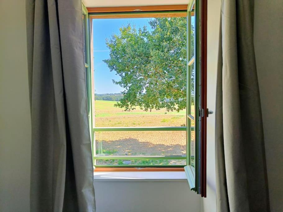 une fenêtre ouverte avec vue sur un champ dans l'établissement Grange moderne près de Rennes avec jolie vue !, à Gévezé