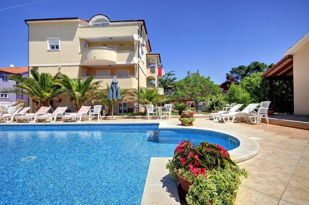 willa z basenem przed budynkiem w obiekcie Attraktive Ferienwohnung mit großem Pool, Klimaanlage, WLAN, BBQ und nur 700 Meter bis zum Sandstrand w Medulinie
