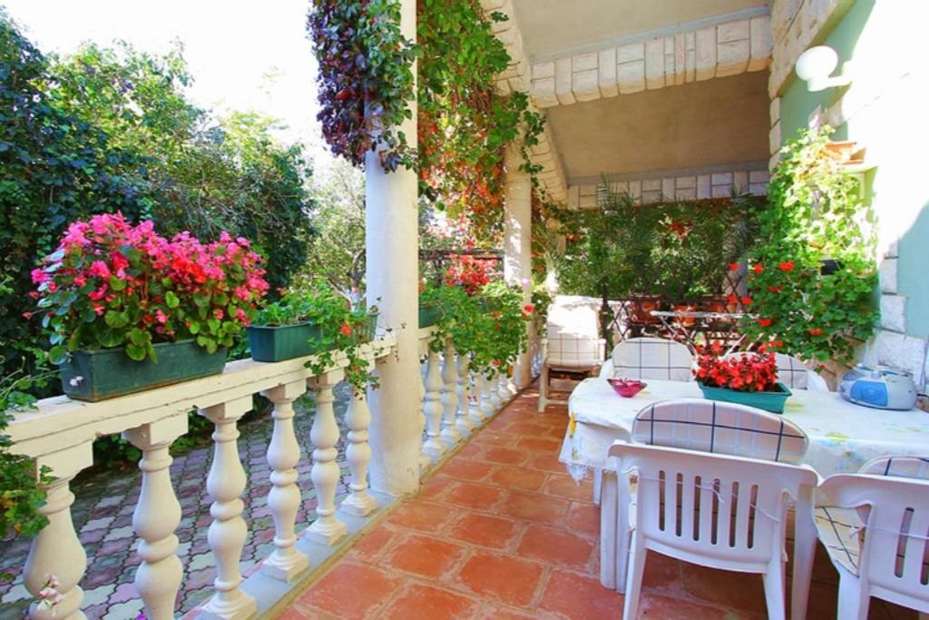 een patio met tafels en bloemen op een balkon bij Ferienwohnung Grace in Medulin