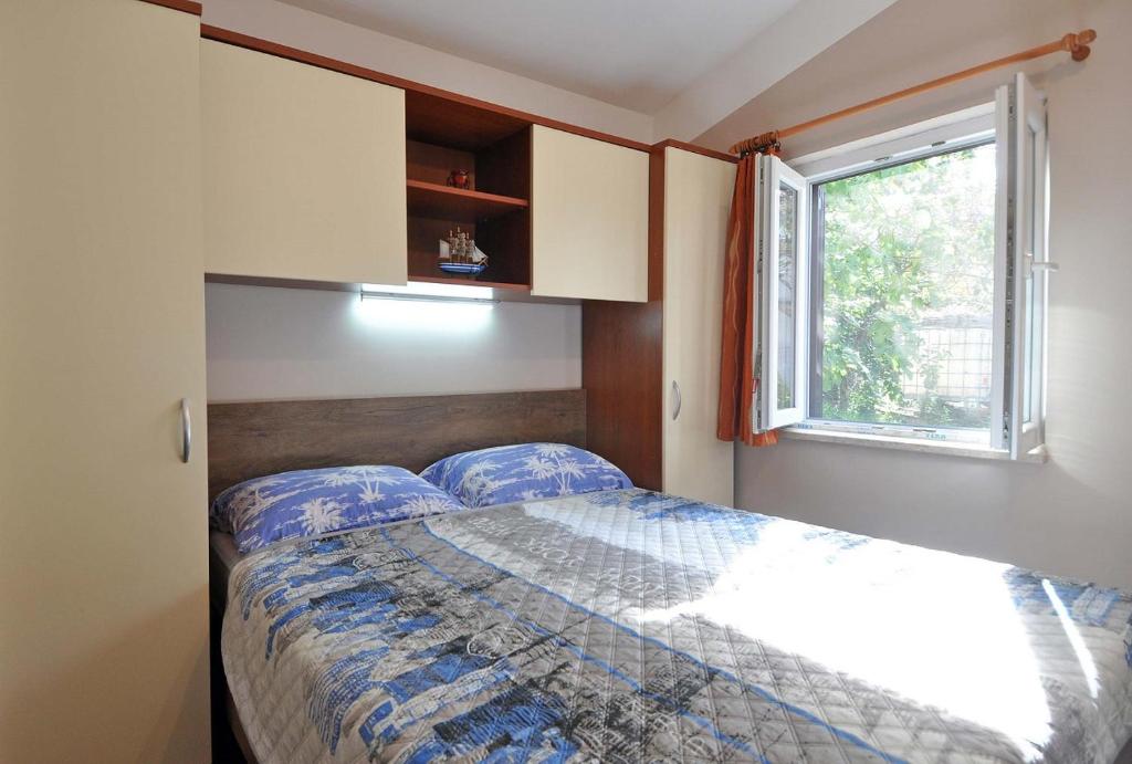 sypialnia z łóżkiem i oknem w obiekcie Herrliches Ferienhaus mit Klima, WLAN, Terrasse und Grillbereich w Puli