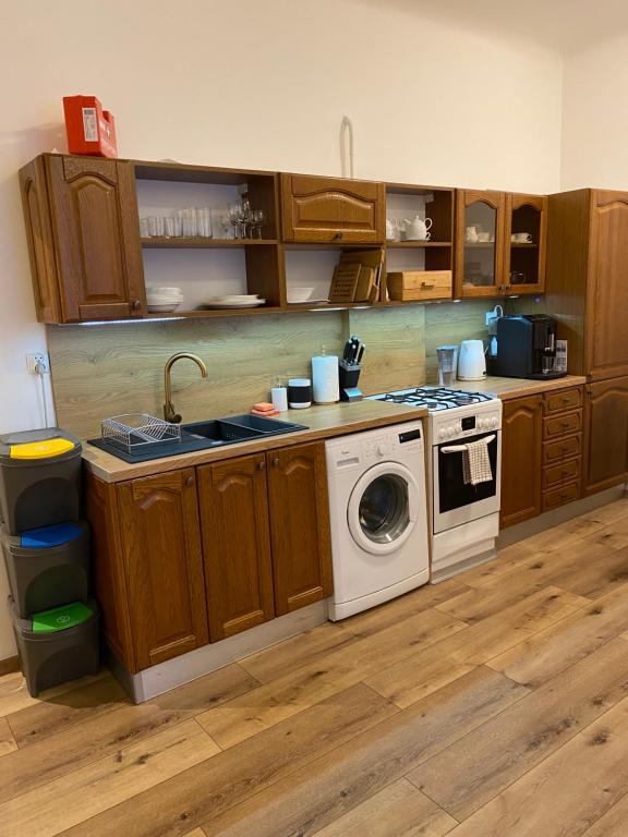 a kitchen with a stove and a washing machine at Nasze Kamienice Apartament Rodzinny in Rzeszów